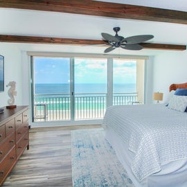 Wake up to waves crashing against the sand in the primary bedroom