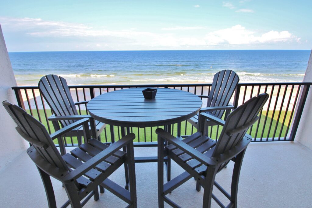 patio table and chairs on balcony overlooking beach
