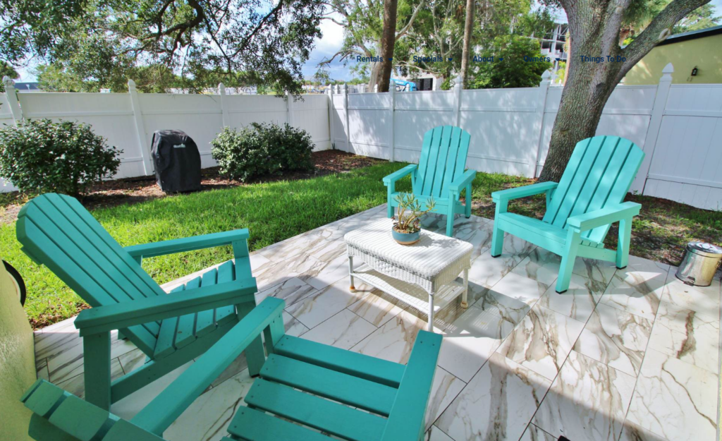 Patio with bright marble look tile and teal outside chairs. 
